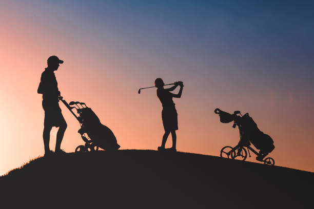 man with his son golfers silhouette stock photo