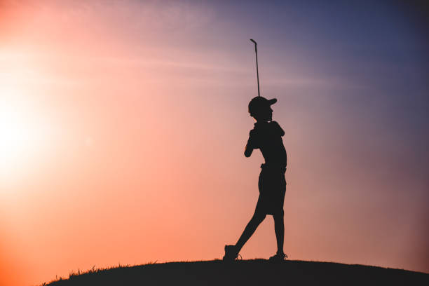 boy golfer silhouette stock photo