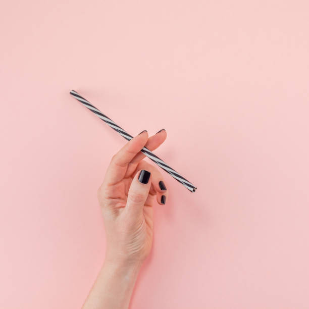 istock Woman hand with cocktail drinking straw 1126127341