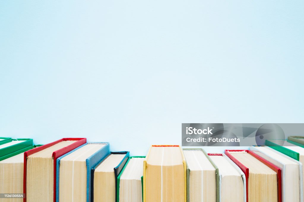 Row of old books with colorful covers on pastel blue background. Education concept. Mock up for different ideas. Empty place for text, quote or sayings. Book Stock Photo