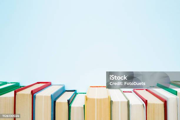 Row Of Old Books With Colorful Covers On Pastel Blue Background Education Concept Mock Up For Different Ideas Empty Place For Text Quote Or Sayings Stock Photo - Download Image Now