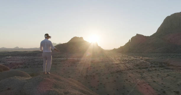 istock Man opening arms on mountain top. Exploring virtual reality at sunset 1126135817