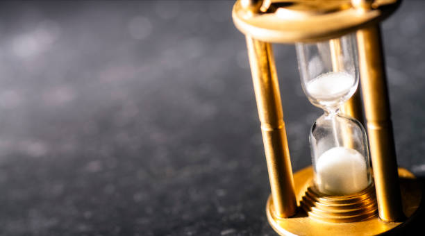 istock Concept timekeeping. Sand trickles through an hourglass 1126136258