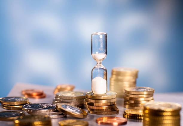 istock Hourglass and many coins 1126136283