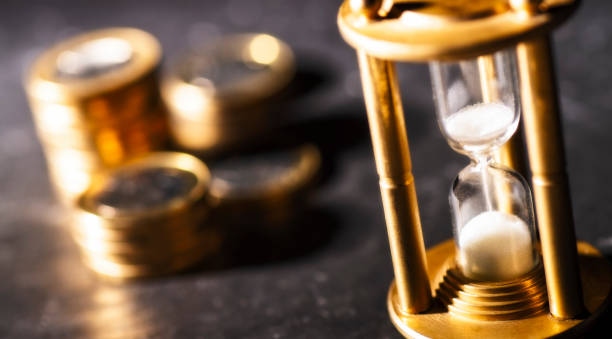 Hourglass and coins concept investment