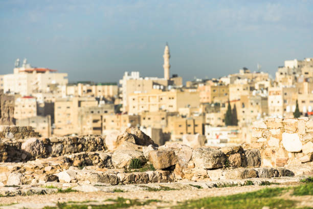 (focus on the rocks in the foreground) Blurred Amman skyline seen from the Amman Citadel in Jordan. The Amman Citadel is a historical site at the center of downtown Amman, Jordan