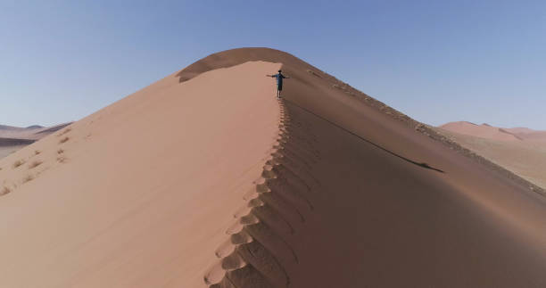 istock Man open arms on huge dune. Exploring with virtual reality. Aerial view 1126136474