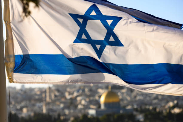 (foco na bandeira) vista do close-up sobre a bandeira de israel com o a cúpula da rocha turva e cidade velha de jerusalém em segundo plano. - dome of the rock - fotografias e filmes do acervo