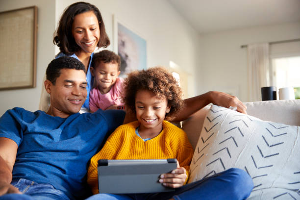 istock Young family spending time together using a tablet computer in their living room, front view 1126138019