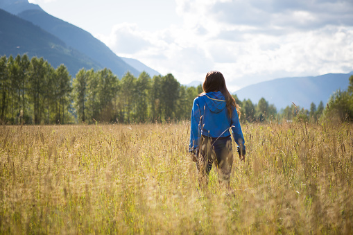 A young indigenous canadian woman walking in a lush open field