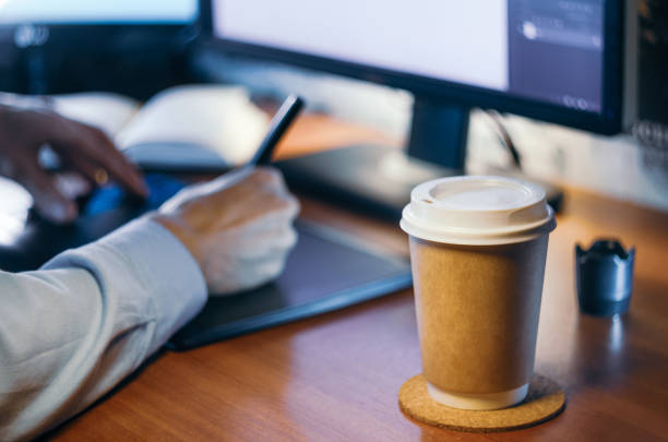 istock Desktop with computer, graphics tablet and a cup of coffee. Side view. 1126139740
