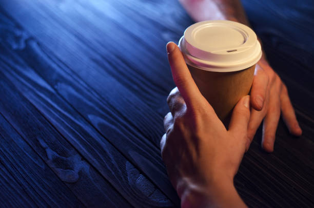 Couple in love holding hands with coffee on wooden table