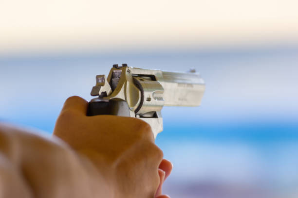 istock Man hold a gun ready to shoot  practicing shooting in the park 1126141232