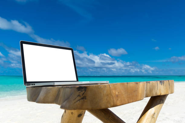 istock laptop blank screen on wooden desk with beach. relax concept. 1126142155