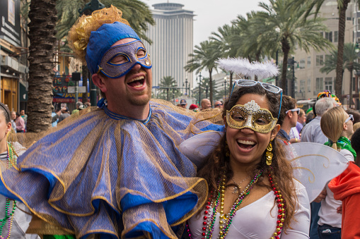 A smiling couple wearing costumes in the street during the Mardi Gras celebration at New Orleans Carnival, Louisiana, USA  The Mardi Gras is a great event held in New Orleans and it is visited yearly by thousands of tourists from all over the world.