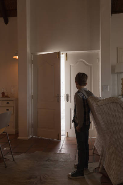 istock Boy standing and looking at door 1126146905