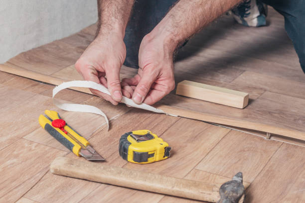 istock Master Class for installing and installing floor sills - the master removes protective paper from adhesive tape 1126154501