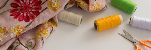 istock Top view of embroidered cloth and colorful threads on white background, space for text 1126157227