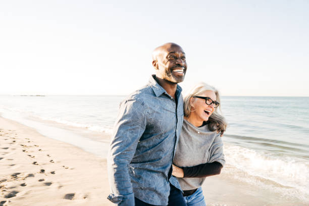 Strategies To Help Increase Your Retirement Income Senior couple walking on the beach common couple men outdoors stock pictures, royalty-free photos & images