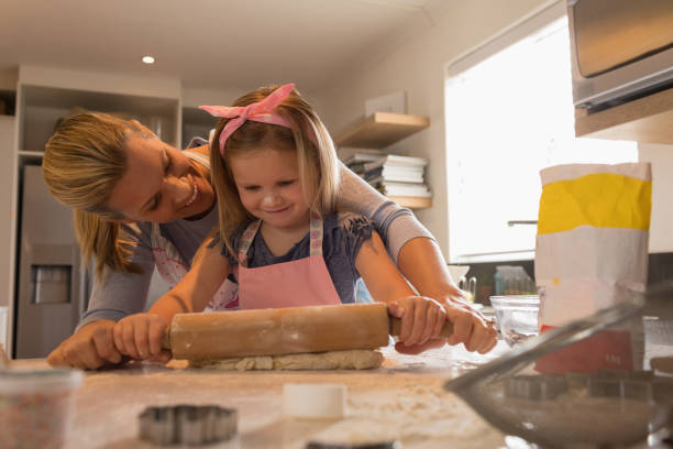 istock Mother with her daughter preparing food in kitchen 1126163667