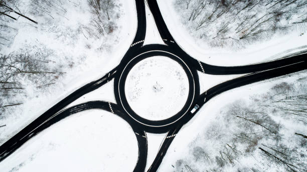 istock Traffic circle and road through wintery forest 1126165070