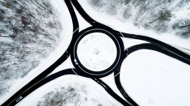 istock Traffic circle and road through wintery forest 1126165081
