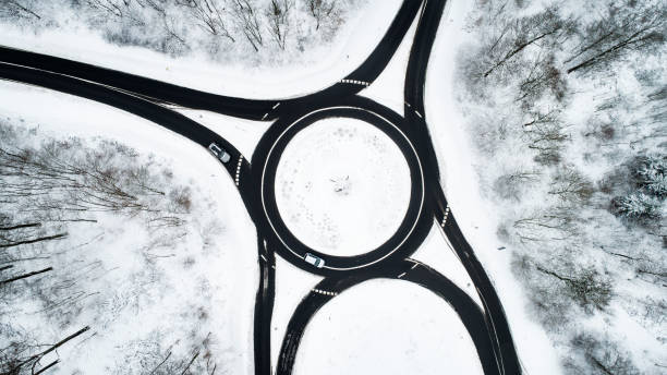 istock Traffic circle and road through wintery forest 1126165129
