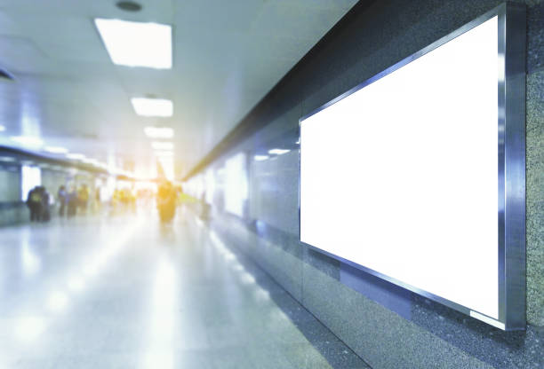 istock blank billboard white screen LED horizontal and perspective advertising banner board indoor in subway station public hall with people walking. 1126170516