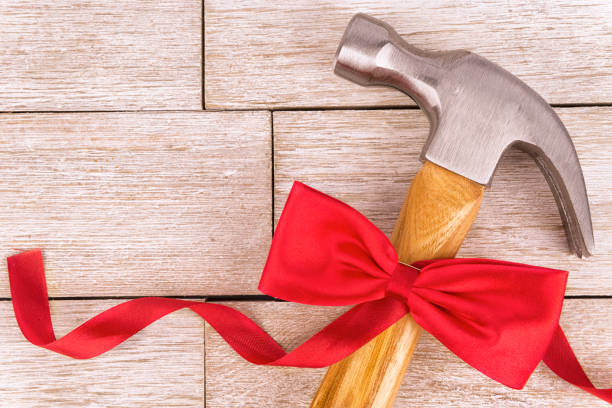 Hammer on a white wooden plank, directly above. Copy space for your text. Offering tool in gift. Concept.