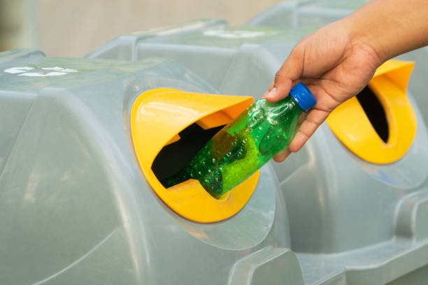 istock Hand holding recyclable plastic bottle in garbage bin with sunset light 1126175372