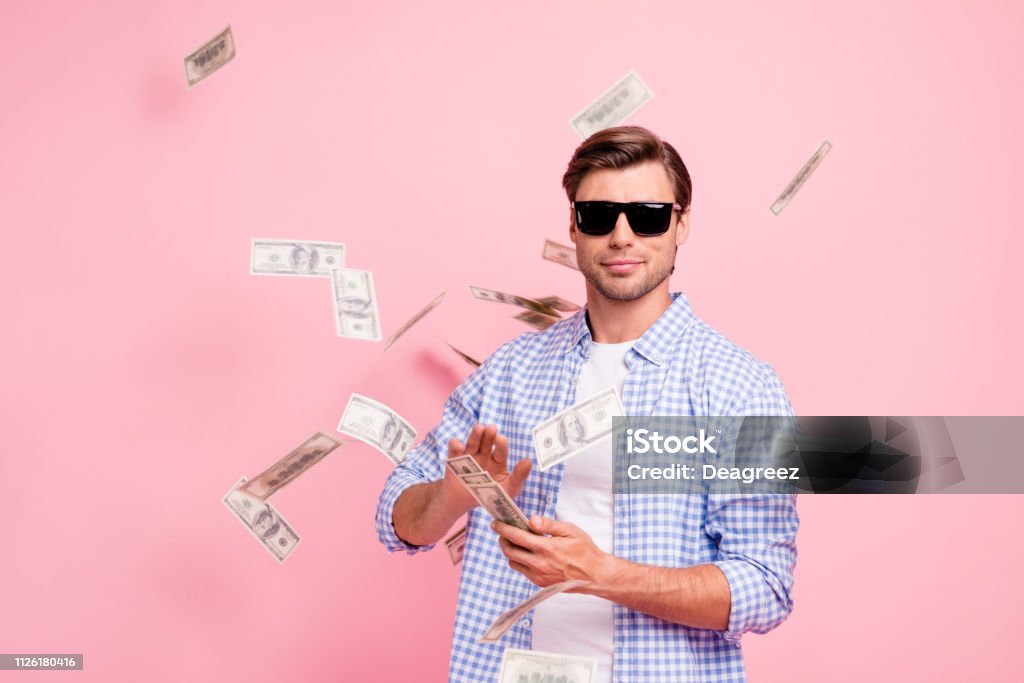 Portrait of his he nice cool trendy content attractive handsome candid guy wearing checked shirt throwing money flying in air party wealth isolated over pink pastel background Currency Stock Photo