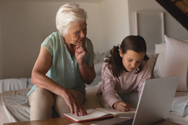 istock Grandmother helping her granddaughter with homework 1126185697