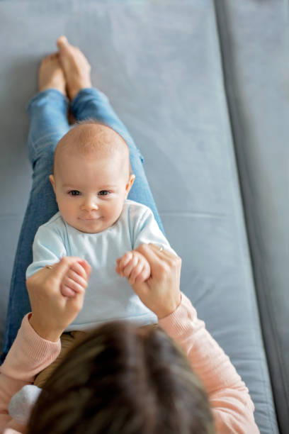 istock Young mother, holding her toddler boy sitting on a couch 1126186055