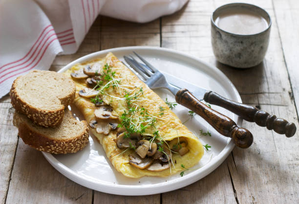 istock Vegetarian breakfast, omelette with mushrooms and cress, served with rye bread and coffee with milk. Rustic style. 1126187876