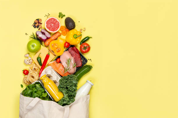 Grocery shopping concept - foods with shopping bag Grocery shopping concept - meat, fish, fruits and vegetables with shopping bag, top view bag photos stock pictures, royalty-free photos & images