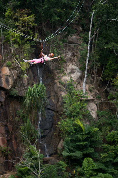 istock Young carefree woman having fun while rappelling from a zip line. 1126189018