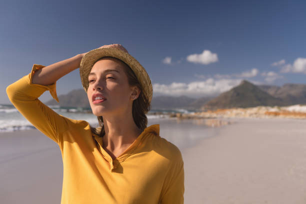 istock Woman in hat standing on the beach 1126195346