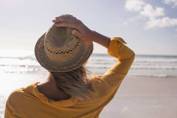 istock Woman in hat standing on the beach 1126195405