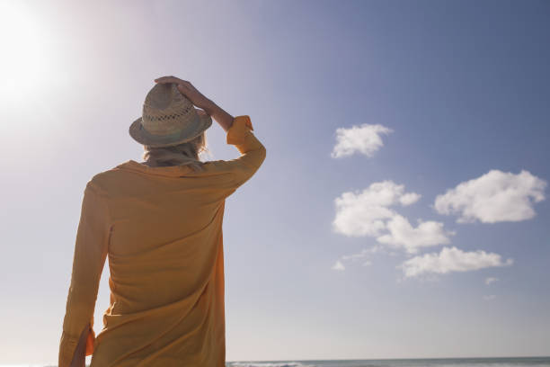 istock Woman in hat standing on the beach 1126195488