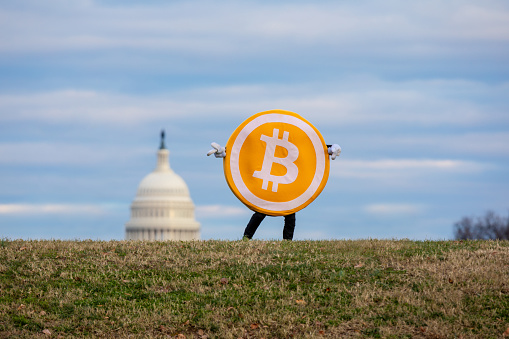 Litecoin and Bitcoin figures stand in front of the U.S. Capitol