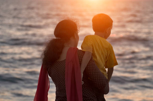 istock young mother with her 5 year old boy on Kerala beach 1126199913
