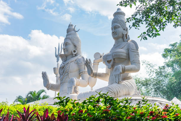 lord shiv & parvati statue at an Indian garden looking awesome with small shrubs. stock photo