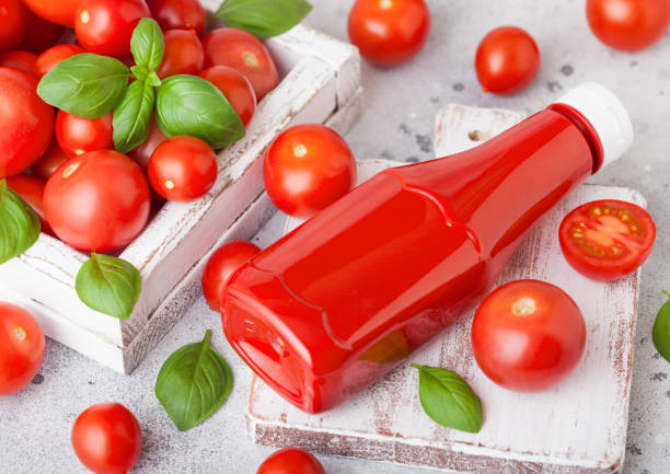 récipient en plastique avec sauce ketchup aux tomates crues sur fond de pierre cuisine. - tomato small food vegetable photos et images de collection