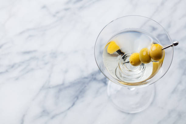 istock Martini cocktail with green olives on marble board. Copy space. Top view. 1126202345