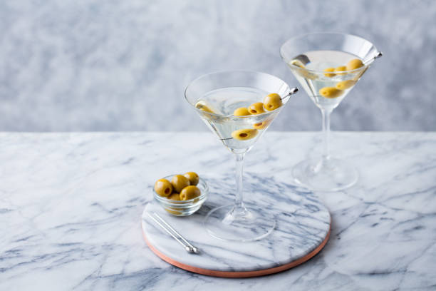 istock Martini cocktail with green olives on marble table background. Copy space. 1126204911