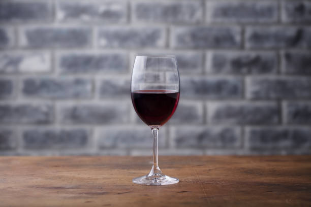istock Glass of red wine on stone wall background. Copy space. 1126205433
