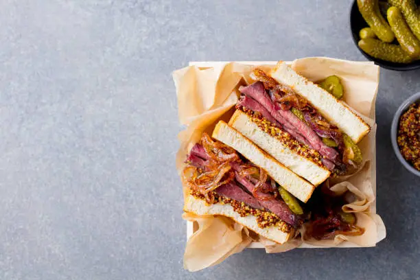 Sandwich with roast beef in wooden box. Top view. Copy space