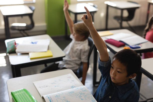 istock Schoolboy raising hand in classroom 1126205776