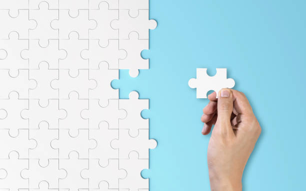 istock Hand putting a piece of white jigsaw puzzle. Pattern texture separated in strategy and solution of team business success partnership concept on blue background. 1126205978