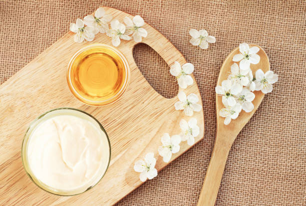 Natural skincare body butter cream, glass jar with honey, fresh blossom top view canvas & wooden board background, preparation diy cosmetics healthy lifestyle botanical spa treatment stock pictures, royalty-free photos & images